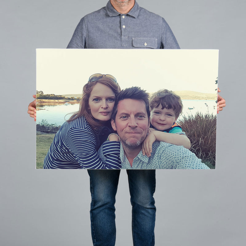 A man holding a 90x60cm canvas print featuring a family selfie in west cork