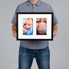 A man holds a custom black-framed double aperture photo collage print against a solid gray background.
