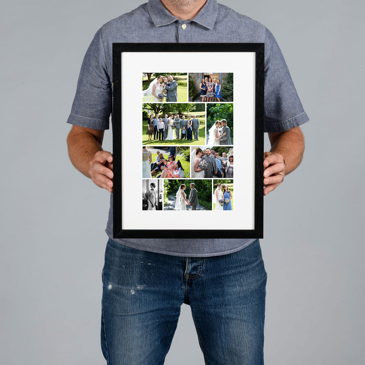 A man wearing a blue polo shirt and jeans holds a custom black framed photo collage print of wedding photographs.  The print is 20x30cm and the frame is 34x44cm. 